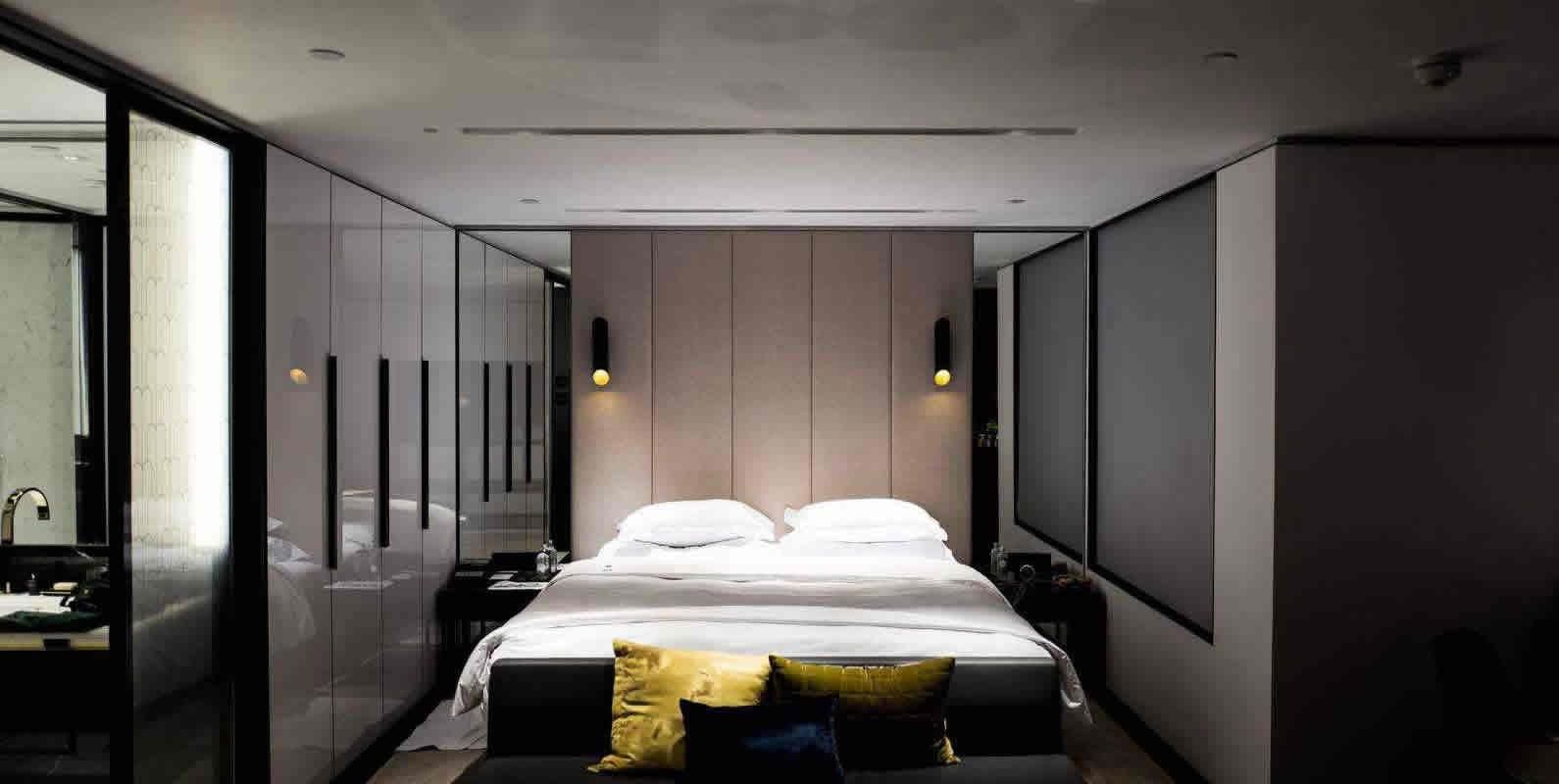 A contemporary bedroom with a large bed, minimalistic decor, and soft lighting, creating a serene and restful space.